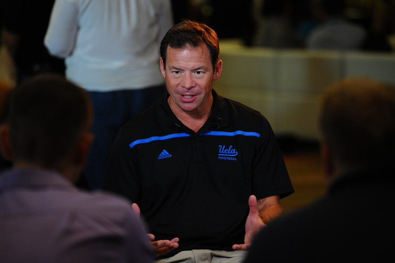 UCLA head coach Jim Mora chats with reporters at Media Day. 