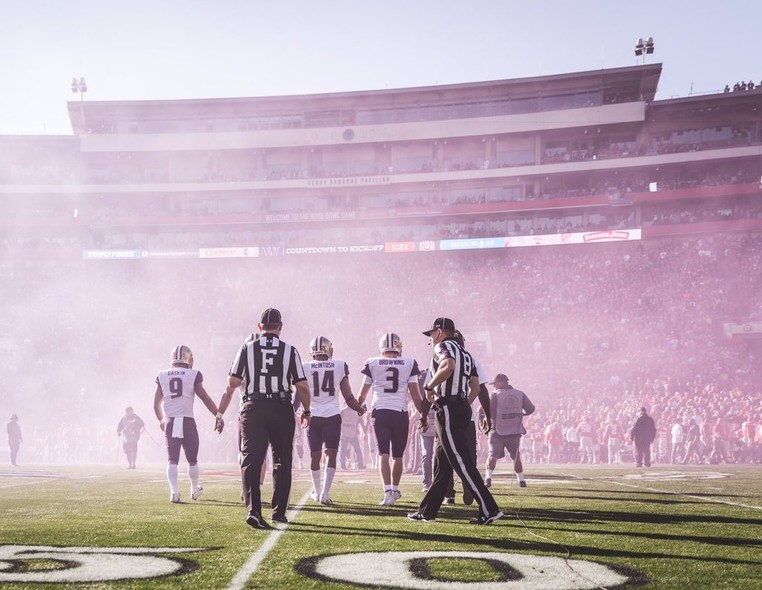 Washington captains lock hands as the smoke settles on the field.