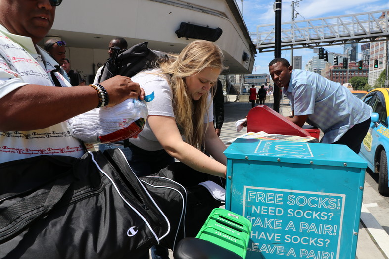 As part of Tuesday's Day of Service with HanesBrands, volunteers add socks to a box for those who need them in downtown Seattle.