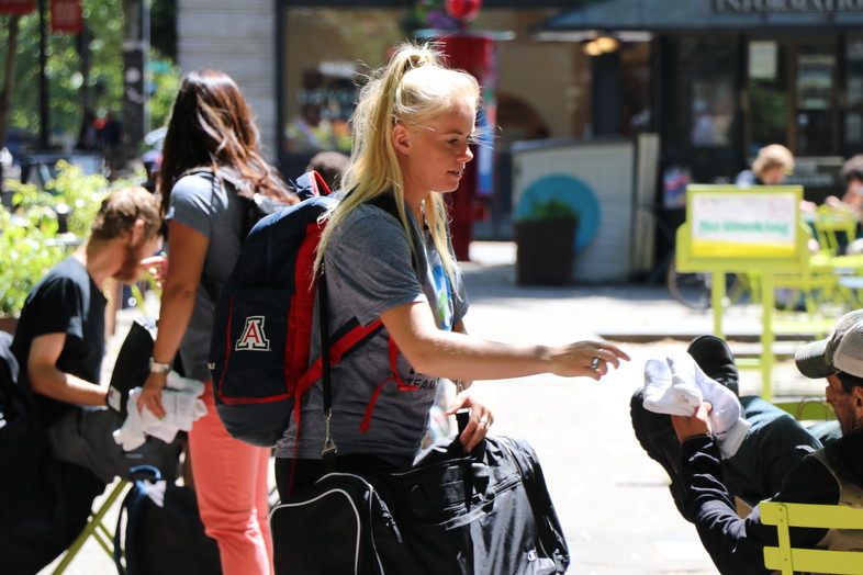 Arizona women's tennis student-athlete Sophia Thomas distributes socks to the homeless in downtown Seattle as part of Tuesday's Hanes Day of Service.