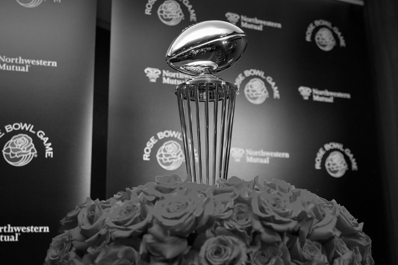 The Rose Bowl trophy stands tall around a bouquet of roses.